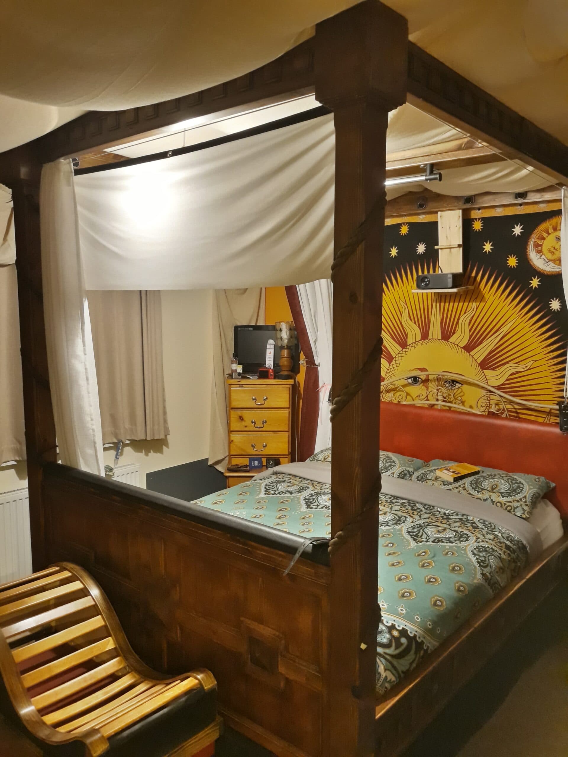 Handcrafted four-poster bed frame surrounding an existing mattress base