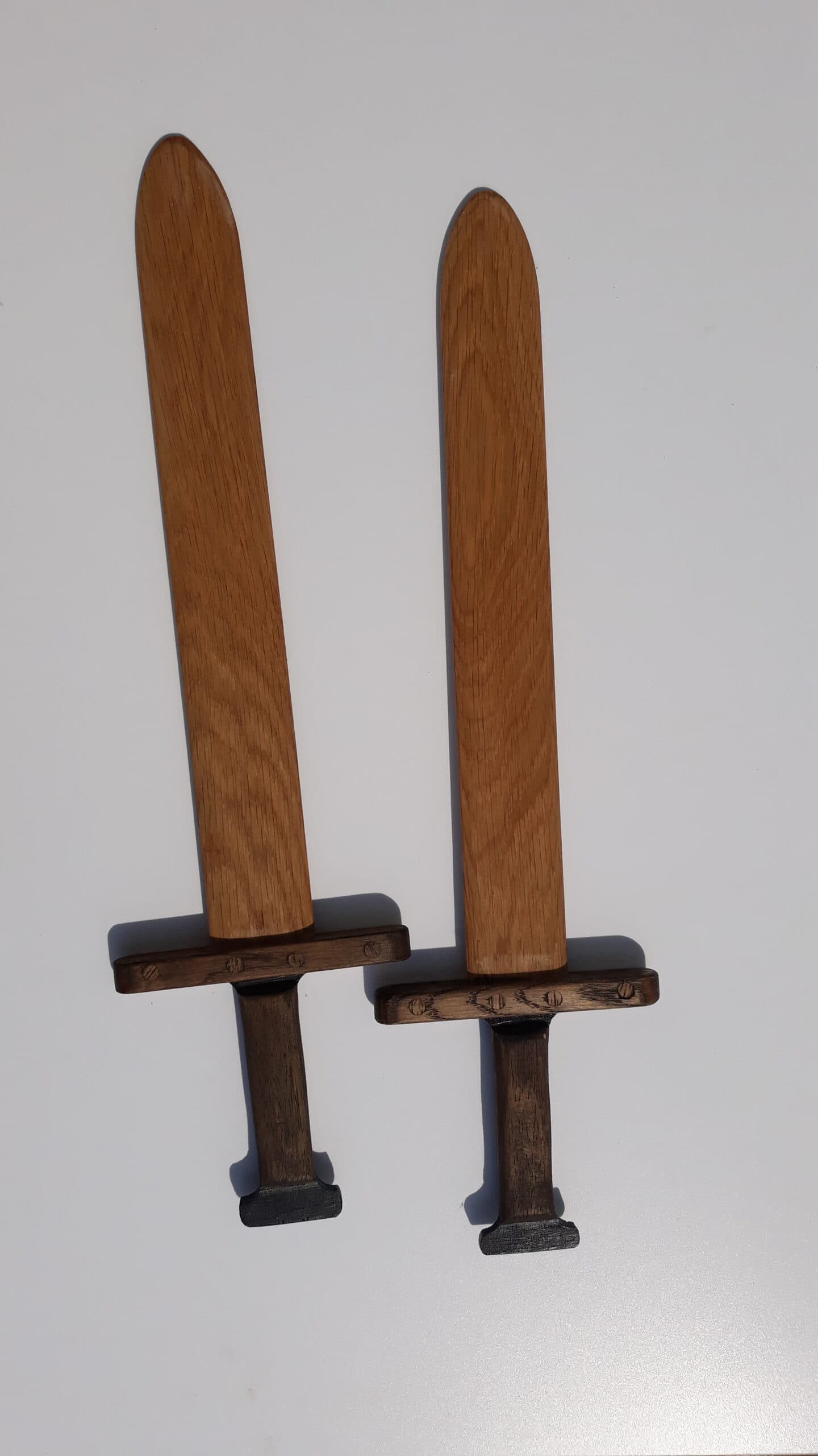 Handmade wooden toy swords and wands on display