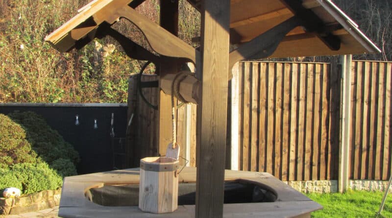 Handcrafted wooden wishing well in a garden